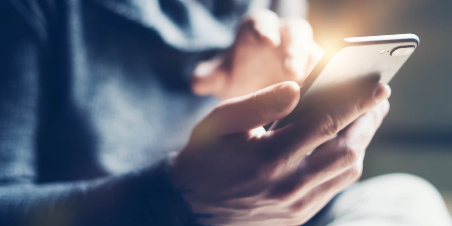 A male hand holding a mobile phone.