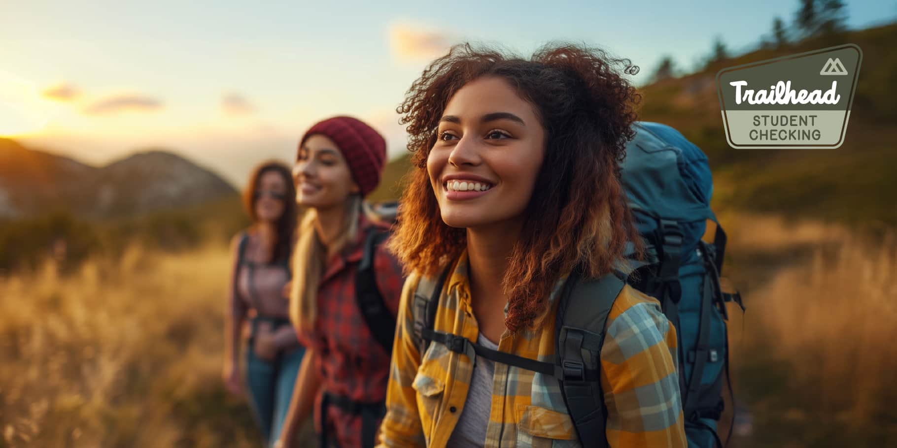 A group of young smiling females hiking.